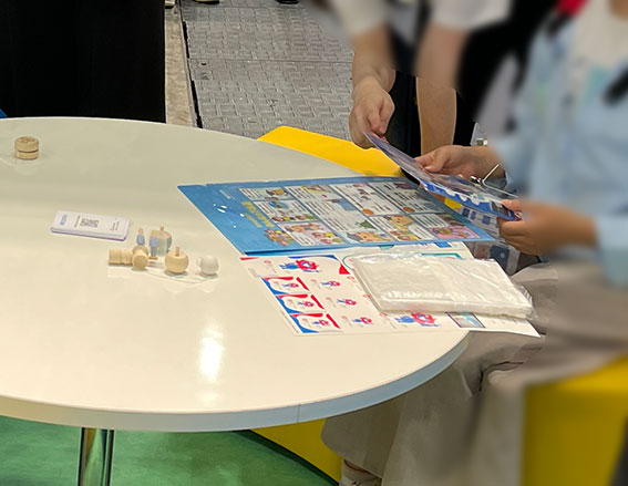 2025年下水道展の明電舎様様のノベルティークリアファイルに描かせて頂いた漫画とイラストです。ノベルティーと来場者の方の様子の写真